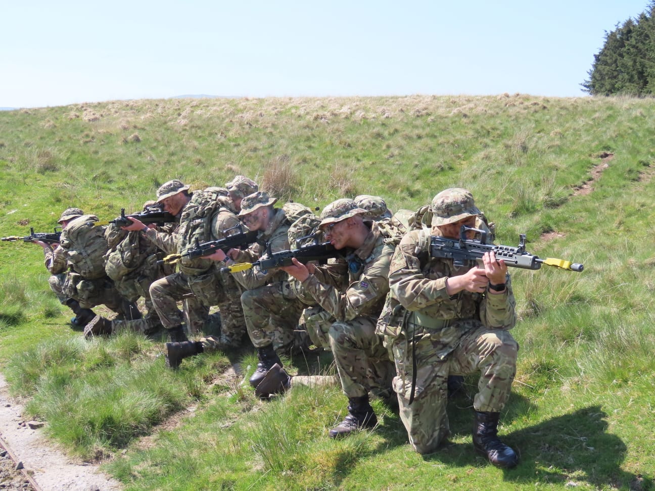 Army cadets crouch in a line.